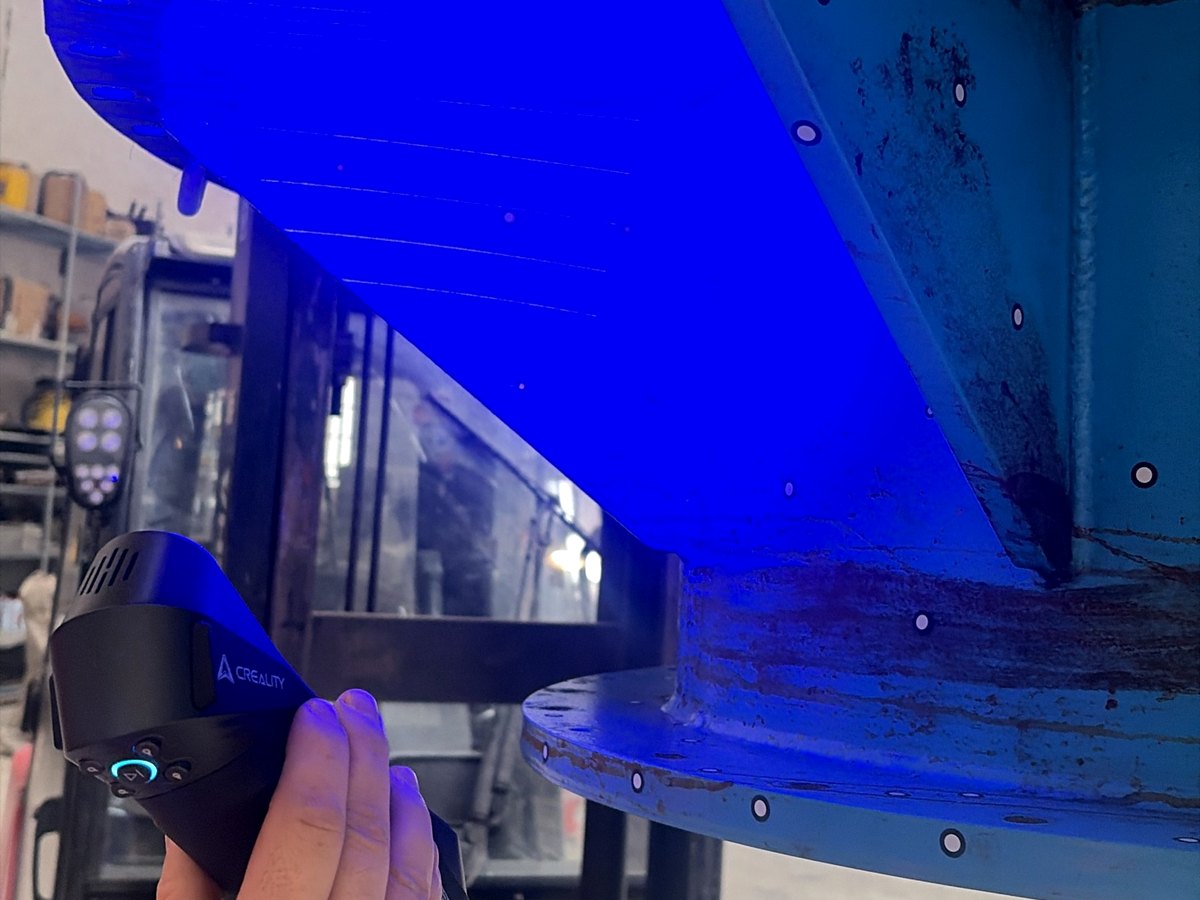 Handscanner met blauw laserlicht op een industrieel onderdeel