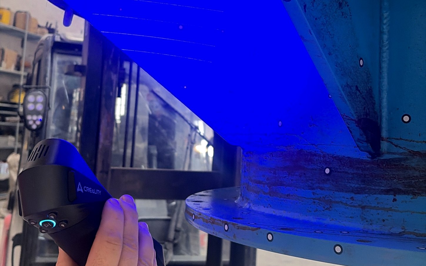 Handscanner met blauw laserlicht op een industrieel onderdeel